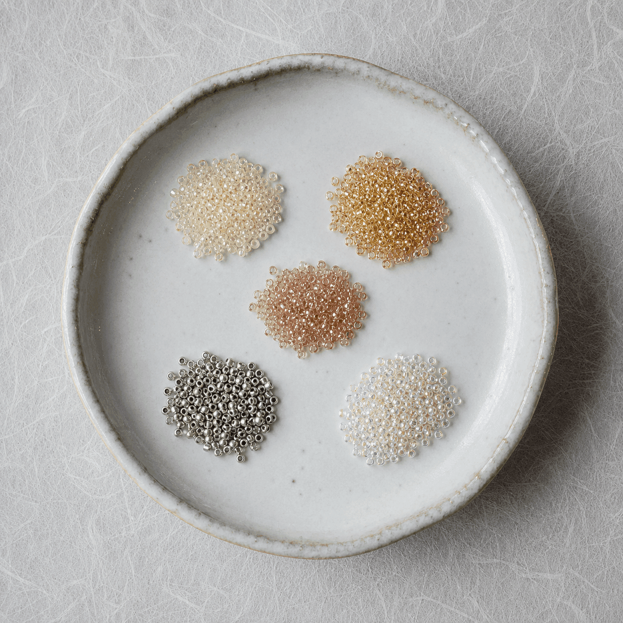 Miyuki seed beads arranged on a Japanese ceramic tray — BBLux atelier